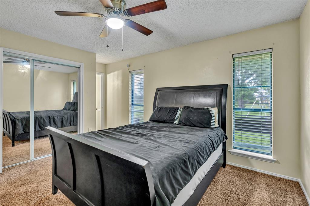 108 Prairie Creek Road Red Oak, TX 75154 - Photo 13 of 19 Bedroom featuring neutral wall paint, textured ceiling, brown carpeting, dual windows with blinds, and mirrored closet doors
