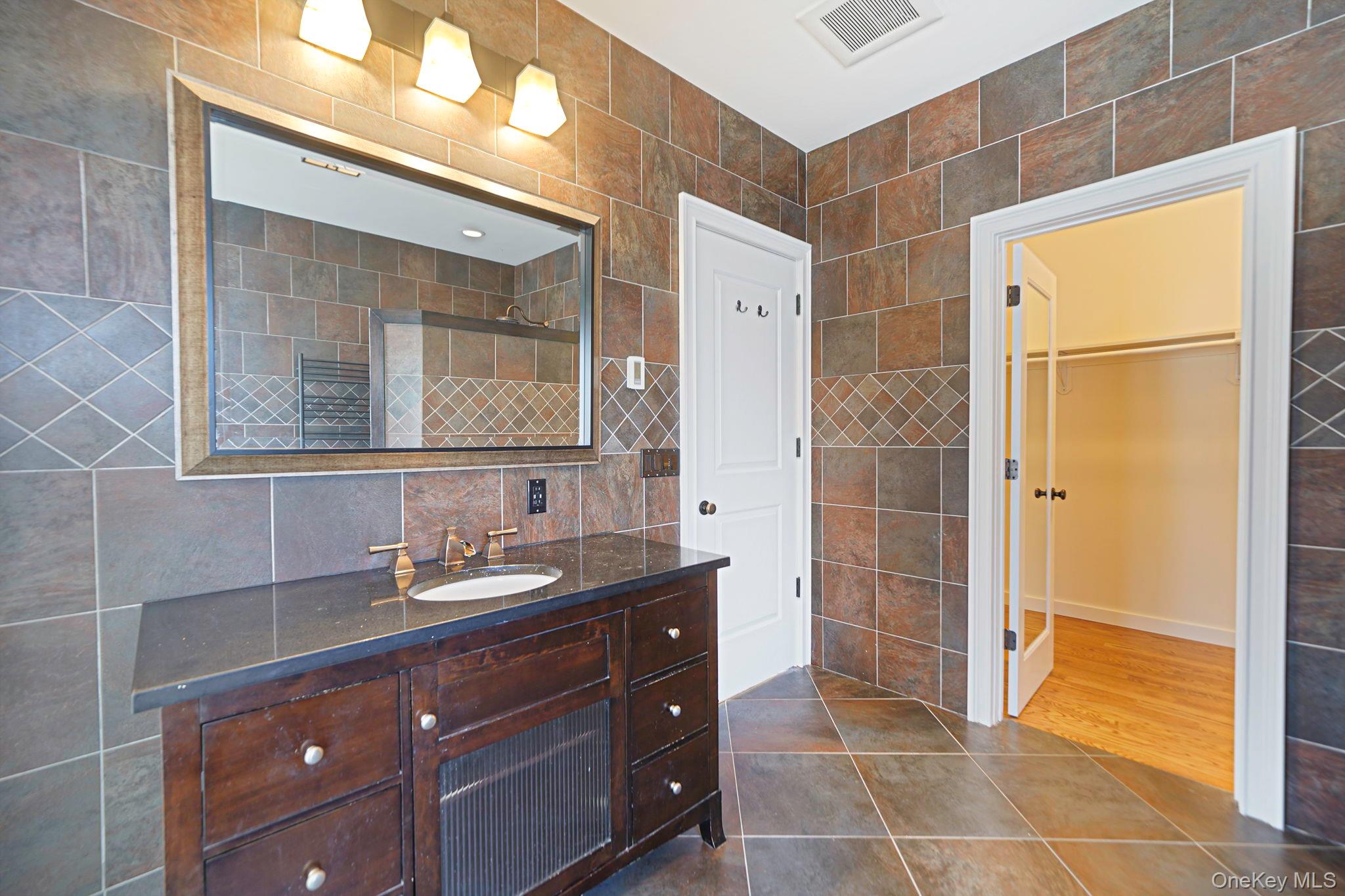 368 Main Street Setauket, NY 11733 - Photo 23 of 41 a bathroom with a granite countertop sink a mirror and a shower