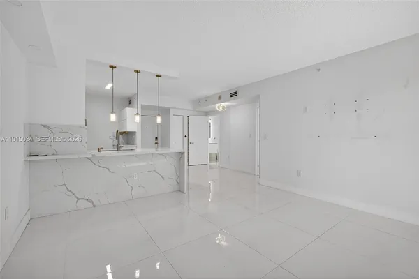 a large white kitchen with white walls cabinets and a sink