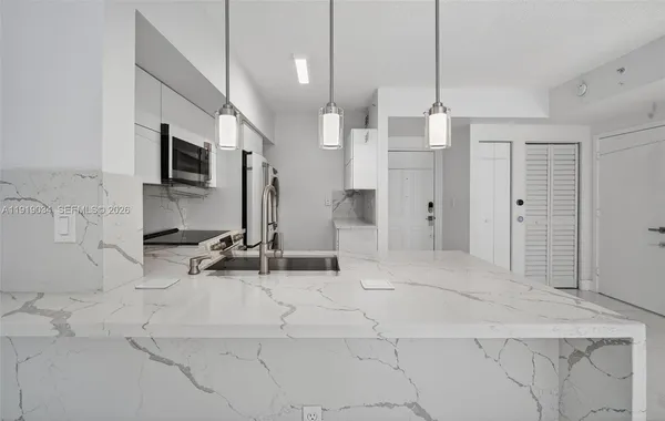 a view of a kitchen with a sink and a chandelier fan