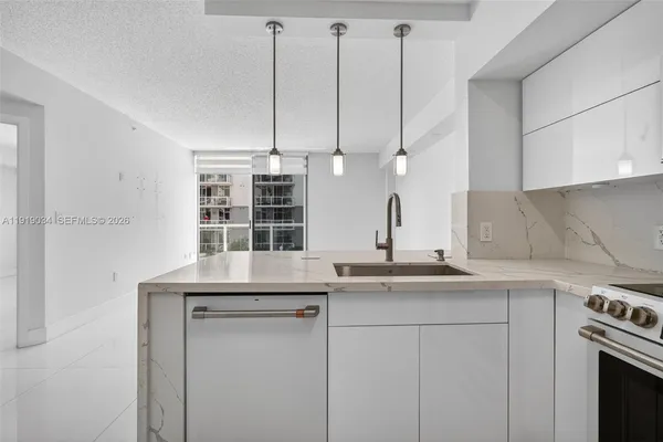 a kitchen with stainless steel appliances granite countertop a sink a stove and a microwave