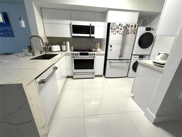 a kitchen with stainless steel appliances a stove a sink and a refrigerator