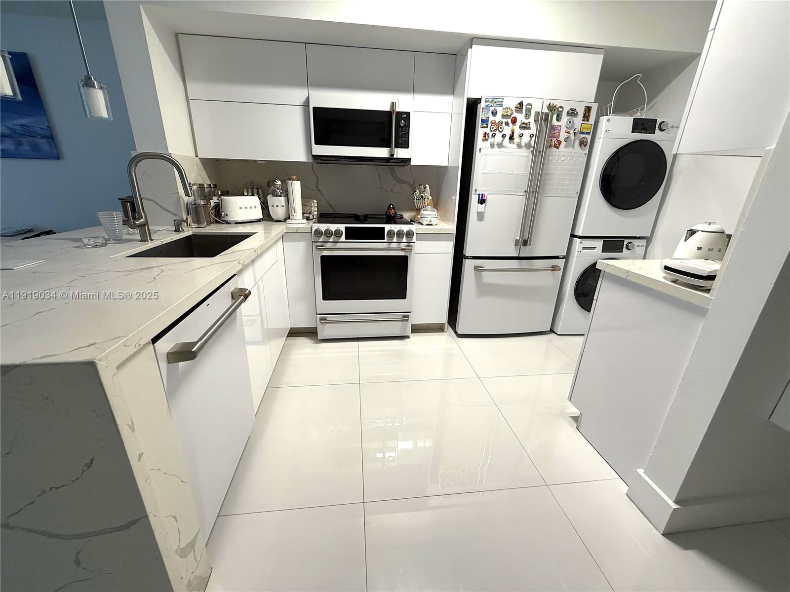 5077 Northwest 7th Street, Unit 610 Miami, FL 33126 - Photo 6 of 20 a kitchen with stainless steel appliances a stove a sink and a refrigerator