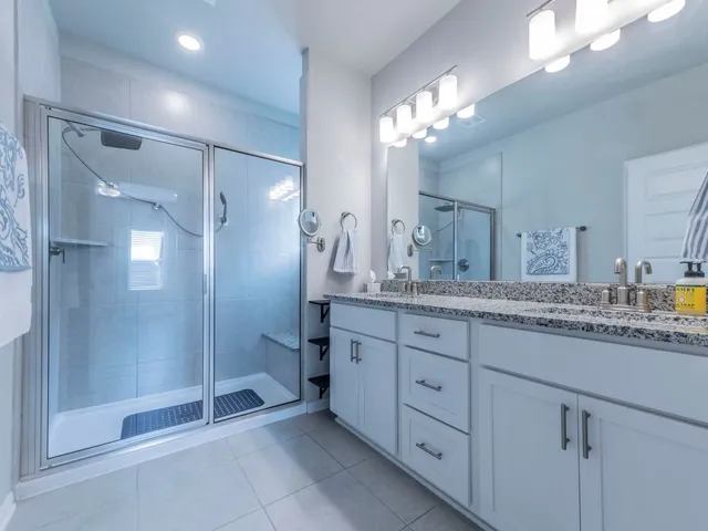 a bathroom with a granite countertop sink a shower and a mirror