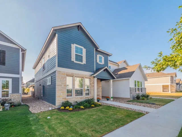 a front view of a house with a yard and trees