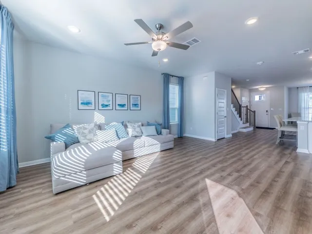 a living room with furniture and a wooden floor