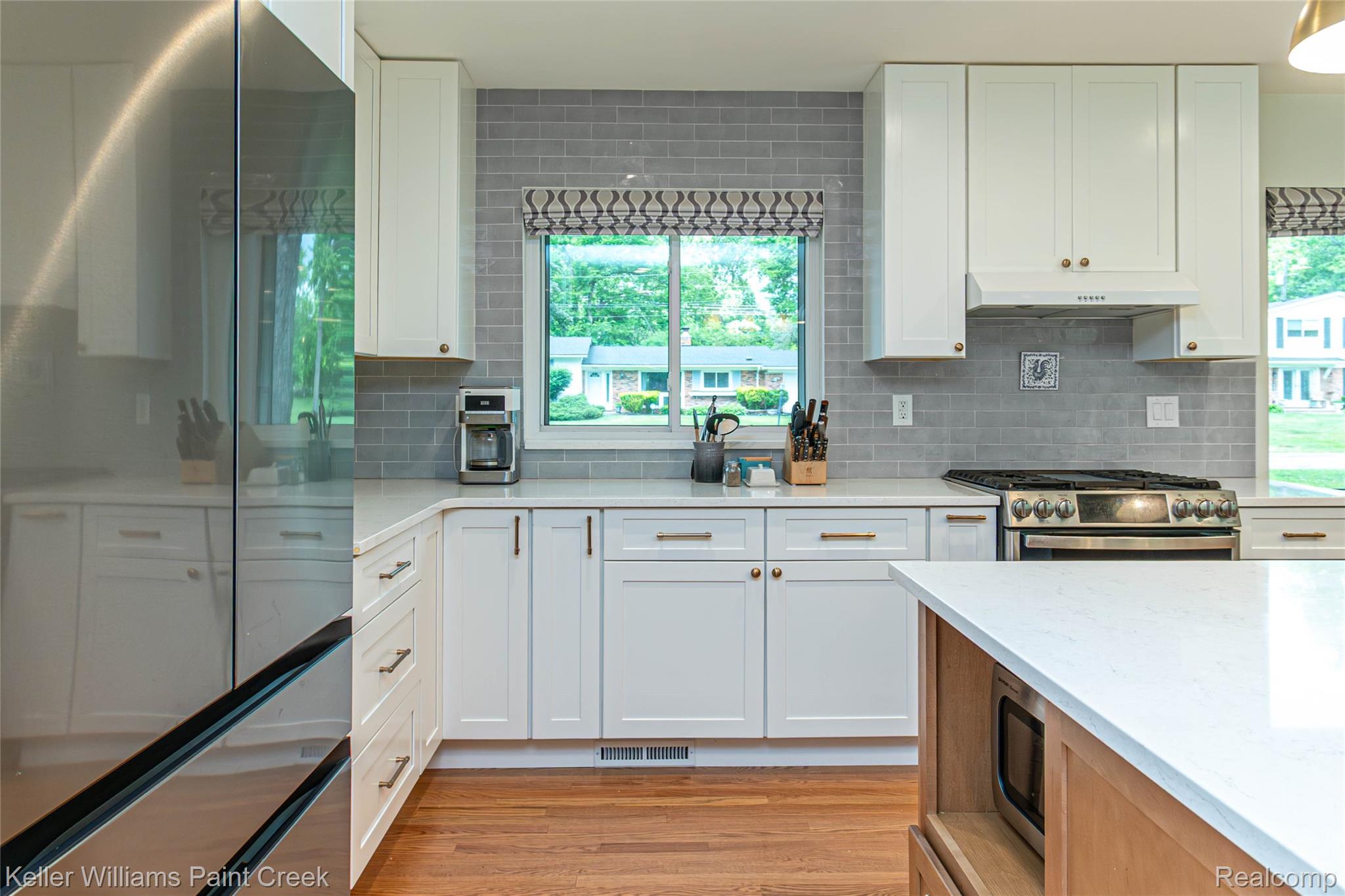 7093 Stonebrook Road West Bloomfield, MI 48322 - Photo 17 of 64 Kitchen featuring white shaker cabinetry, light-toned countertops, and a gray subway tile backsplash