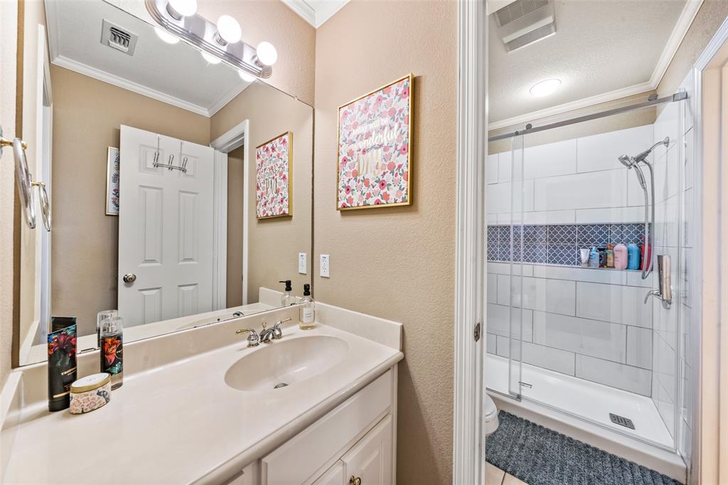 517 Chado Lane Robinson, TX 76706 - Photo 26 of 40 Bathroom #2 featuring ornamental molding, a stall shower, vanity, and a textured wall
