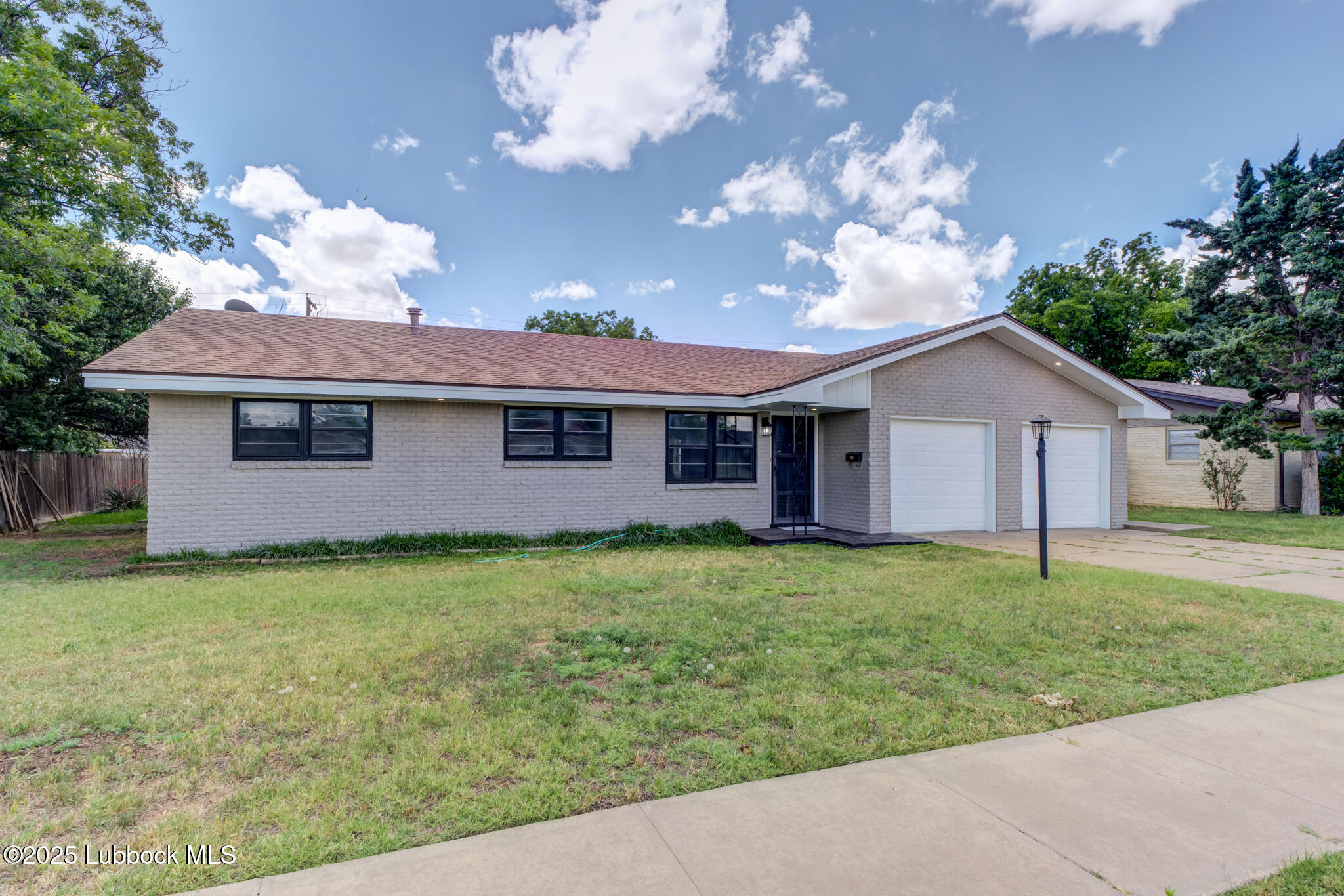 2803 West 18th Plainview, TX 79072 - Photo 2 of 32 a view of a yard in front of a house with plants and large tree