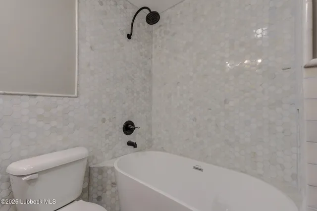 a bathroom with a toilet and a tub