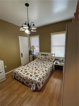 a bedroom with a bed and a chandelier