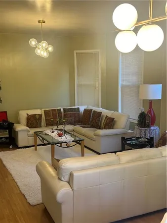 a living room with furniture a lamp and a chandelier