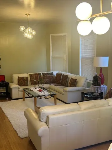 a living room with furniture a lamp and a chandelier