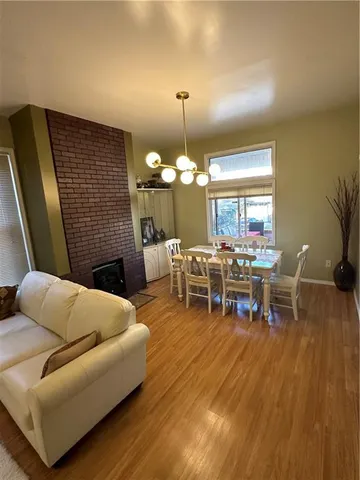 a living room with furniture a dining table and a chandelier