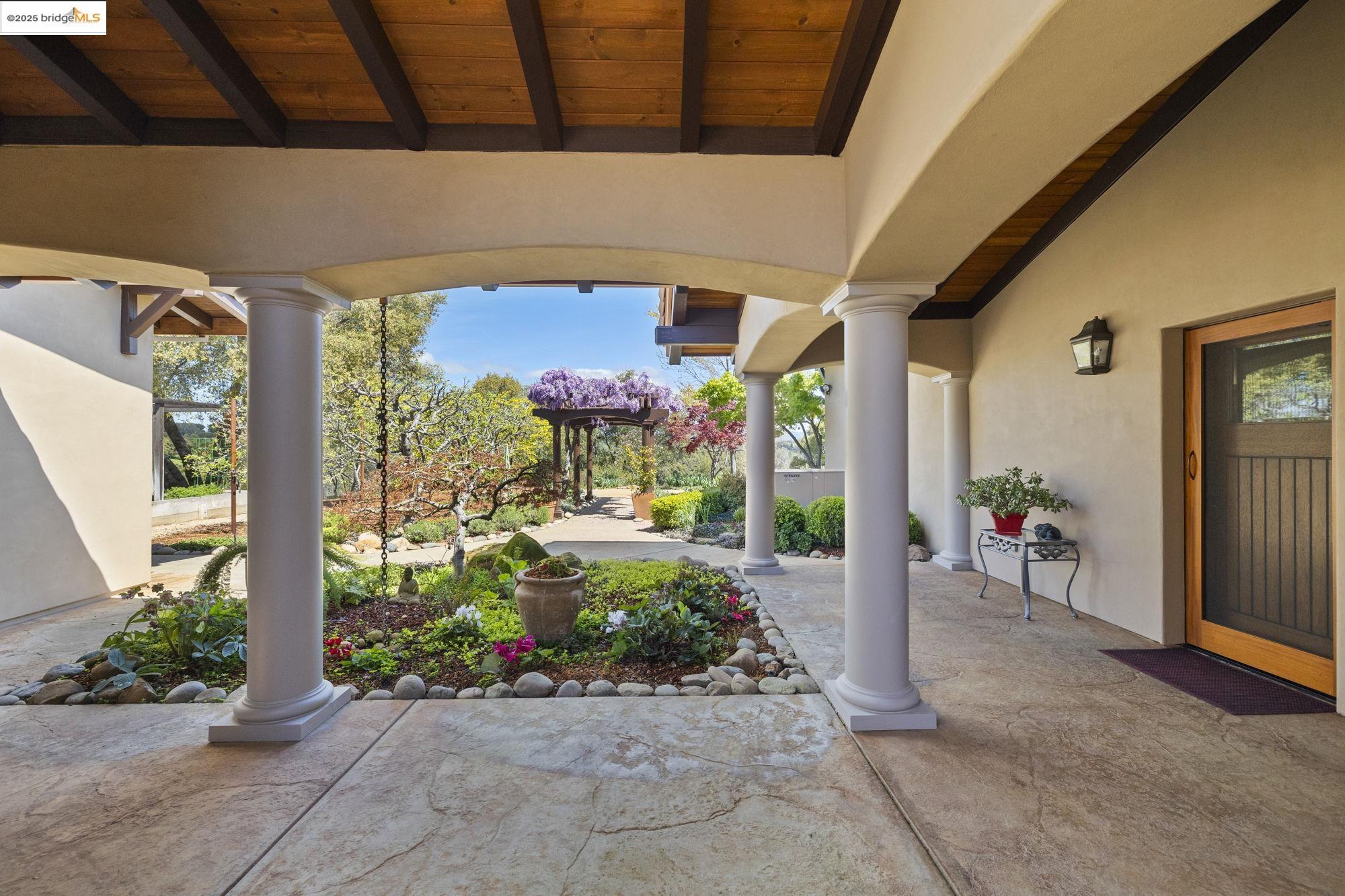 10270 Slate Rim Road Sonora, CA 95370 - Photo 37 of 55 a view of a porch with dining table and chairs under an umbrella