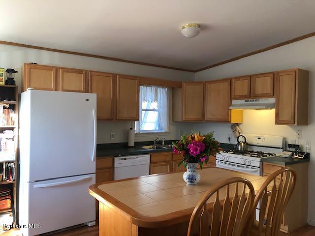 125 Middlefield Road Peru, MA 01235 - Photo 2 of 45 a kitchen with granite countertop a refrigerator a stove a sink dishwasher and white countertops with wooden floor