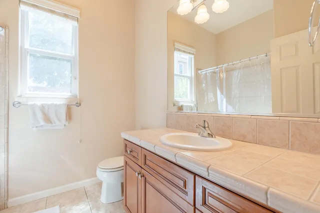 a bathroom with a sink a toilet and a window