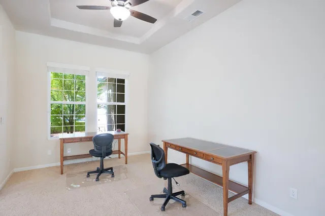a view of a workspace with furniture and a window