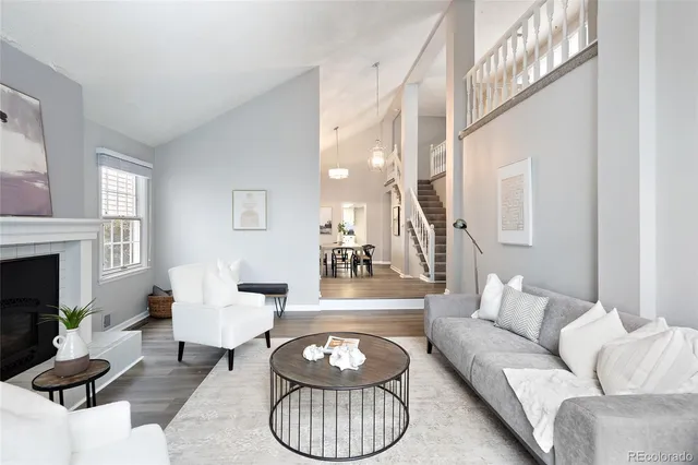 a living room with furniture a fireplace and a potted plant
