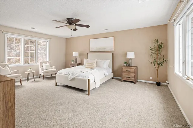 a spacious bedroom with a bed a table and a chandelier
