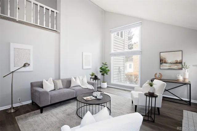 a living room with furniture a table and chair with wooden floor