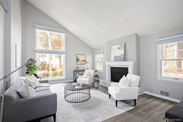 a living room with furniture a fireplace and a window