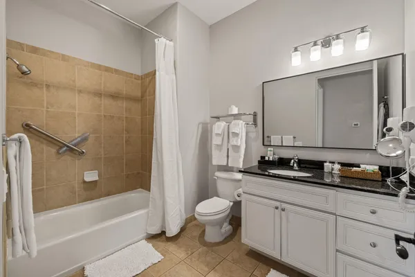 a bathroom with a double vanity sink a toilet a mirror and shower