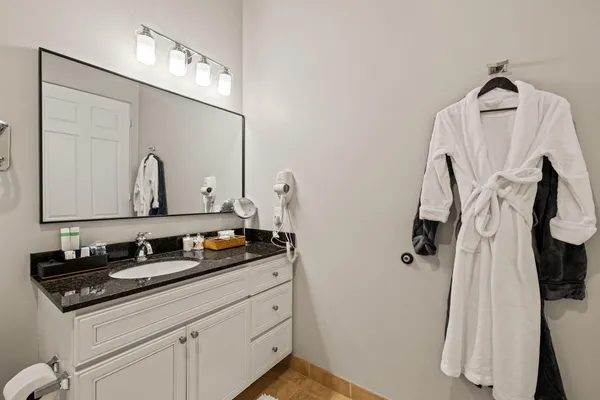 a bathroom with a sink vanity granite and a mirror