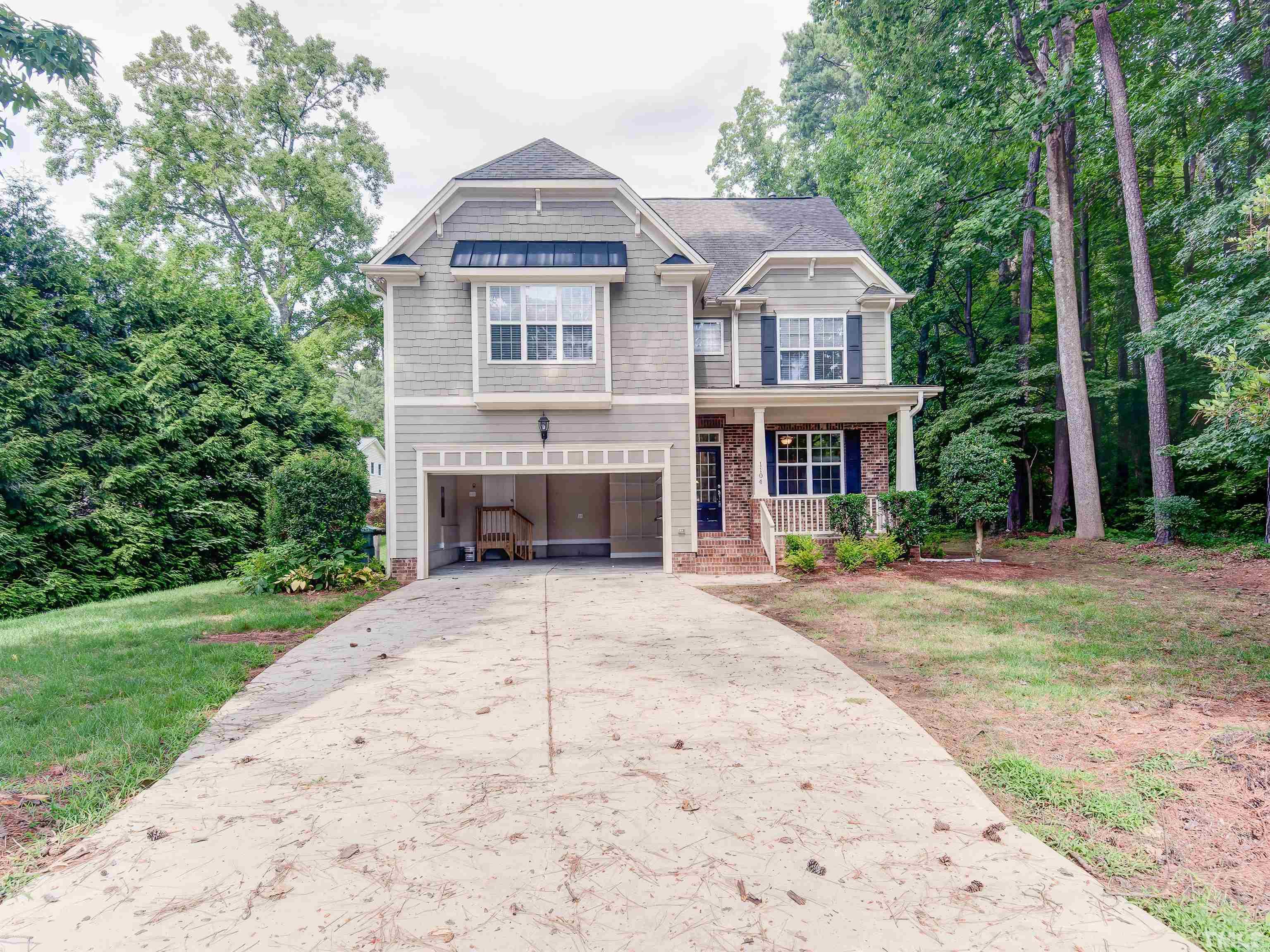 1104 Kingston Ridge Road Cary, NC 27511 - Photo 1 of 26 a front view of a house with a garden and porch