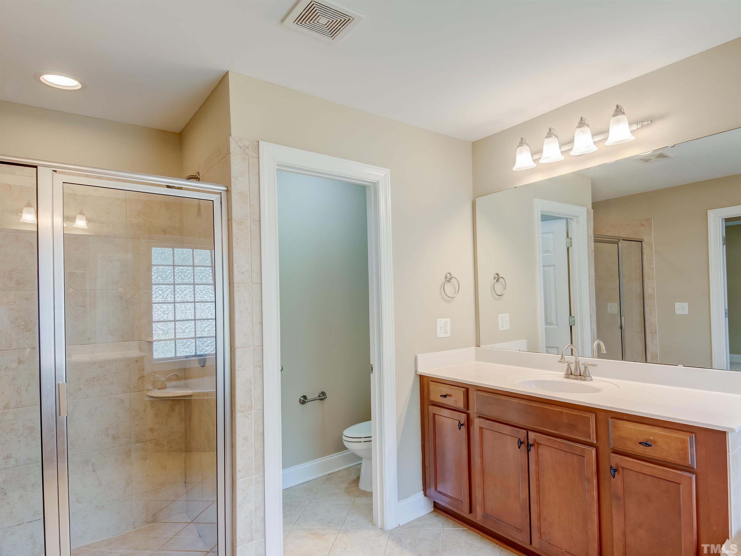 1104 Kingston Ridge Road Cary, NC 27511 - Photo 19 of 26 a bathroom with a double vanity sink and a mirror