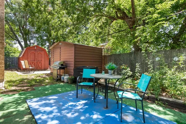 a backyard of a house with table and chairs