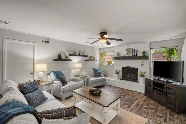 a living room with furniture a flat screen tv and a fireplace
