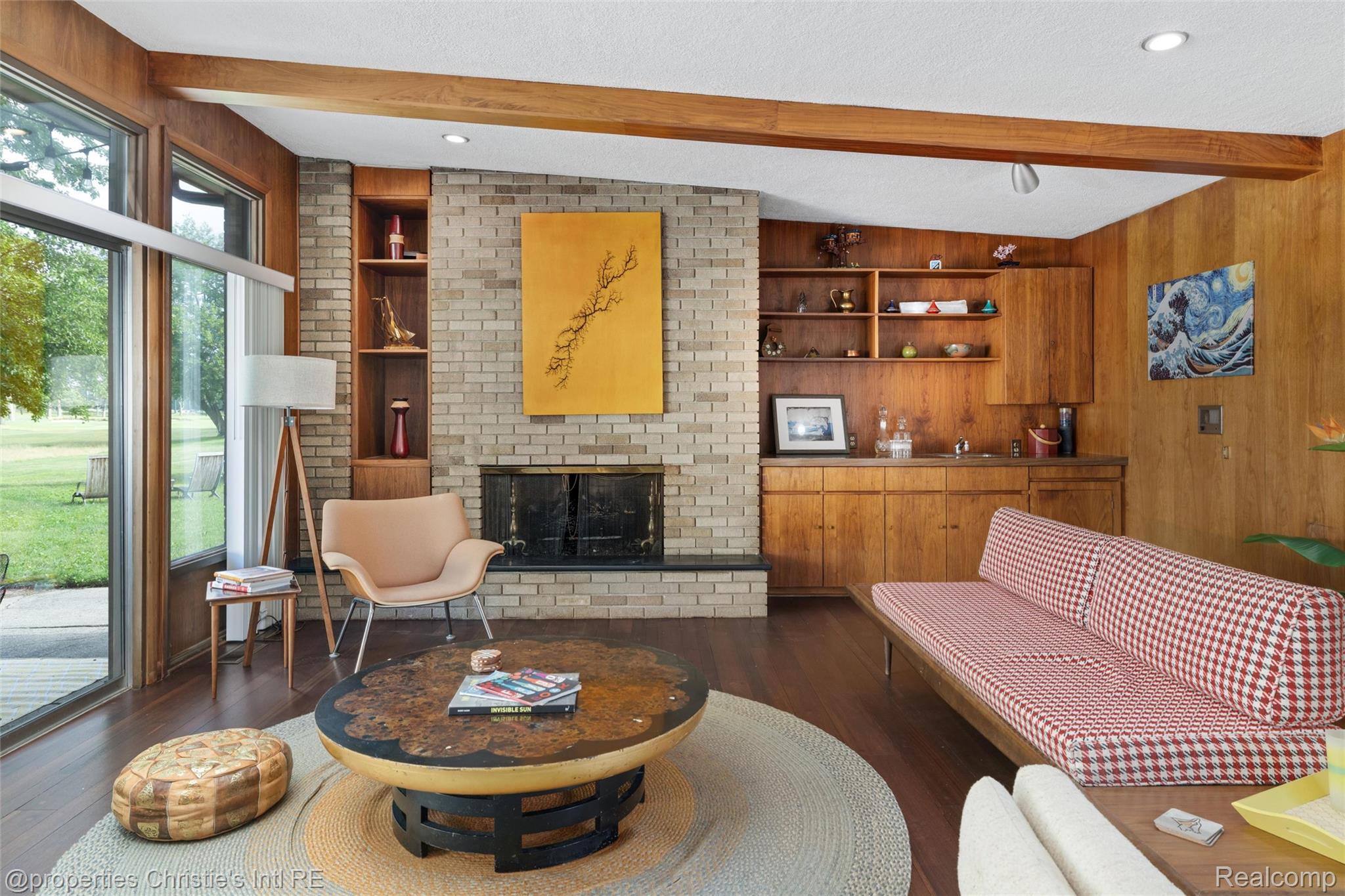 2771 West Seven Mile Road Detroit, MI 48221 - Photo 5 of 57 Living area featuring wood-finish flooring, a brick fireplace, exposed wood beams, and a built-in wet bar with wood cabinetry and shelving