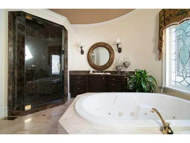 a bathroom with a tub sink and mirror