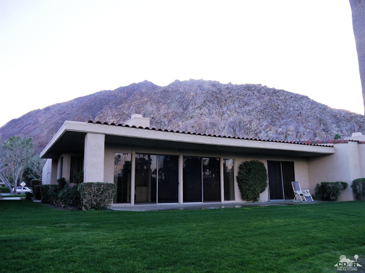 46330 Dove Road Indian Wells, CA 92210 - Photo 1 of 25 a view of a brick house with a big yard and large trees