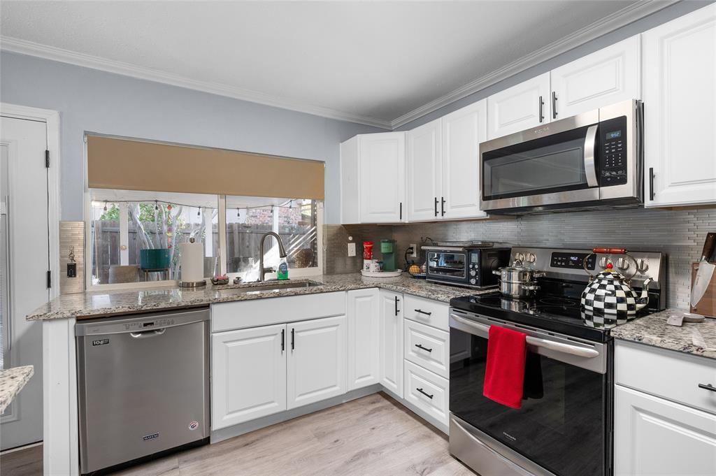 2038 Rose Hill Road Carrollton, TX 75007 - Photo 9 of 35 a kitchen with stainless steel appliances granite countertop a stove a sink and a microwave