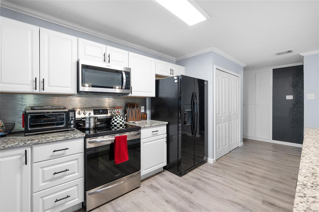 2038 Rose Hill Road Carrollton, TX 75007 - Photo 10 of 35 a kitchen with stainless steel appliances a stove microwave and refrigerator
