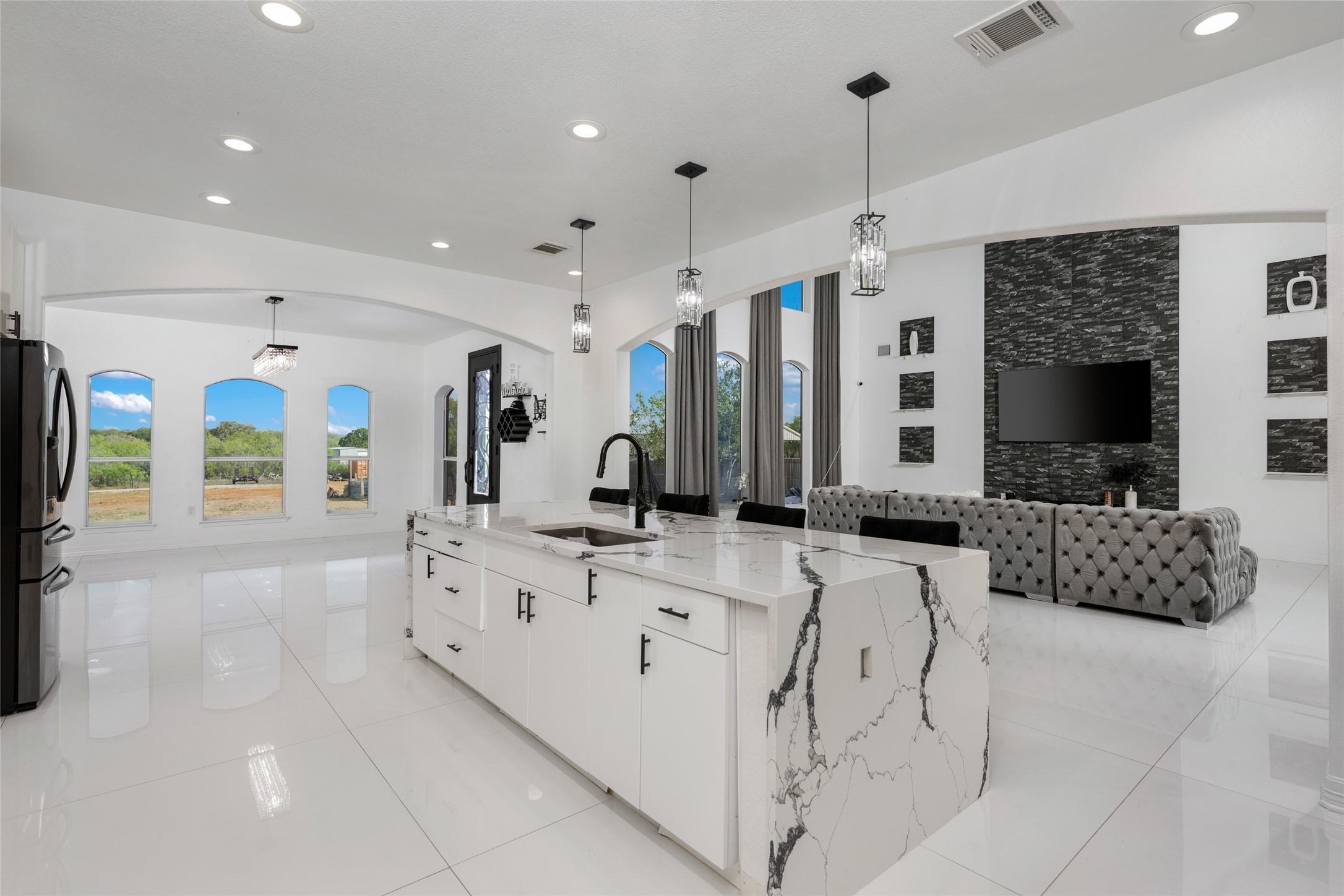 507 Rawhide Road Seguin, TX 78155 - Photo 40 of 40 Kitchen featuring open floor plan, white cabinets, light stone counters, a spacious island, and decorative light fixtures