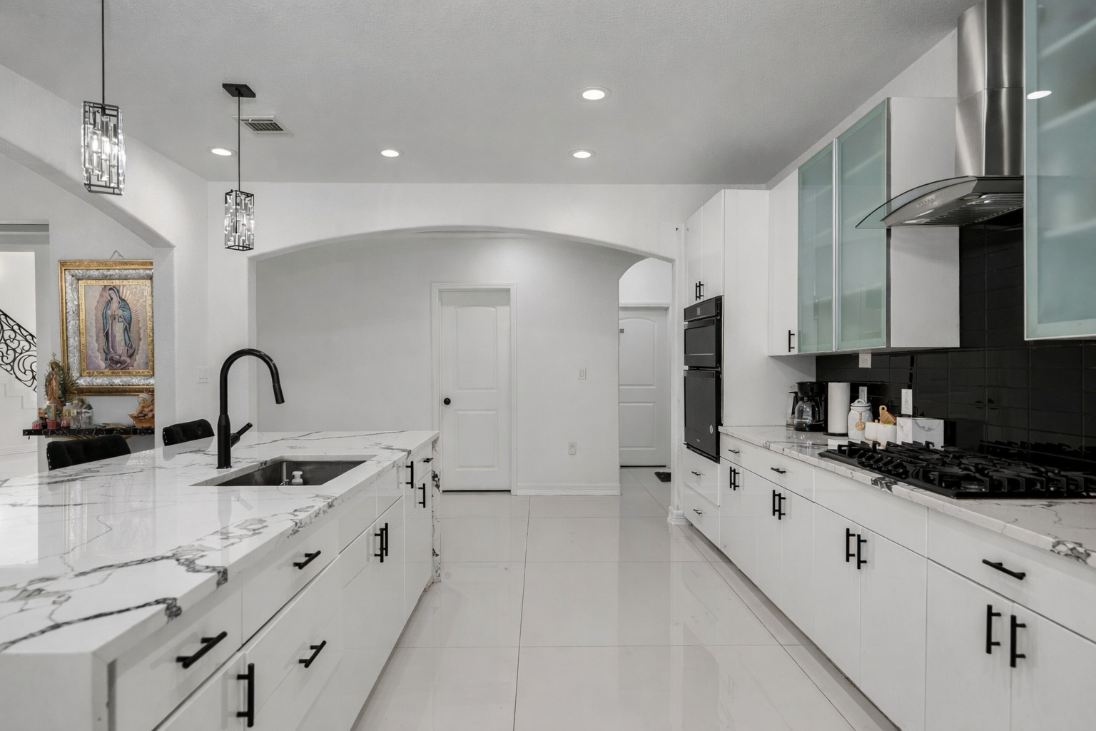 507 Rawhide Road Seguin, TX 78155 - Photo 15 of 40 Kitchen featuring white cabinetry, light stone counters, decorative light fixtures, glass fronted cabinets, and black appliances