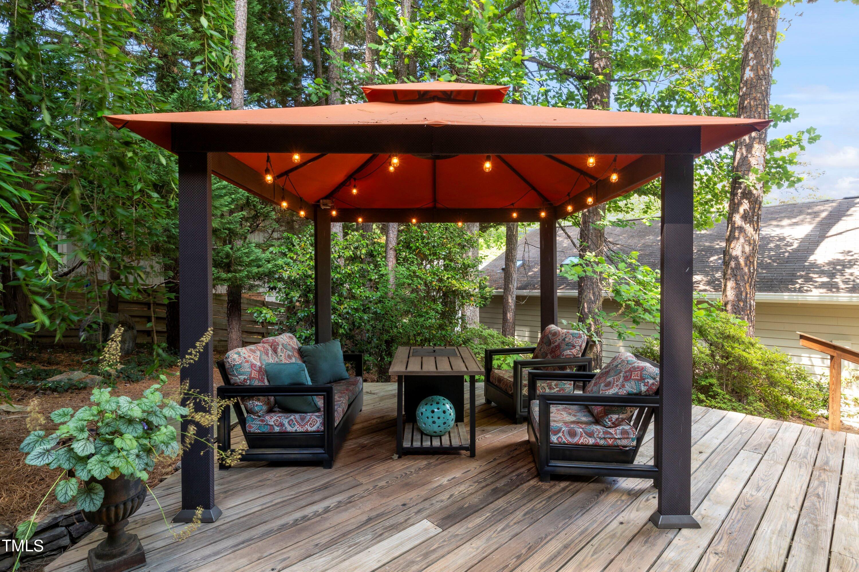 2762 Rue Sans Famille Raleigh, NC 27607 - Photo 33 of 35 a view of patio with a table and chairs under an umbrella with a small yard
