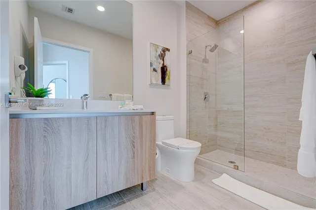 a bathroom with a granite countertop sink a toilet and shower