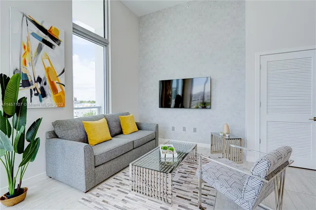a living room with furniture potted plant and a window