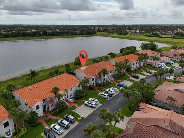 an aerial view of a tennis ground and a cars park side of the road