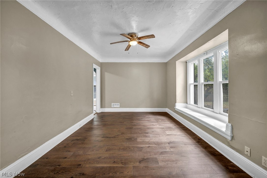 1677 Carlyon Road East Cleveland, OH 44112 - Photo 12 of 41 Unfurnished room with dark wood-style floors, a textured ceiling, and a ceiling fan