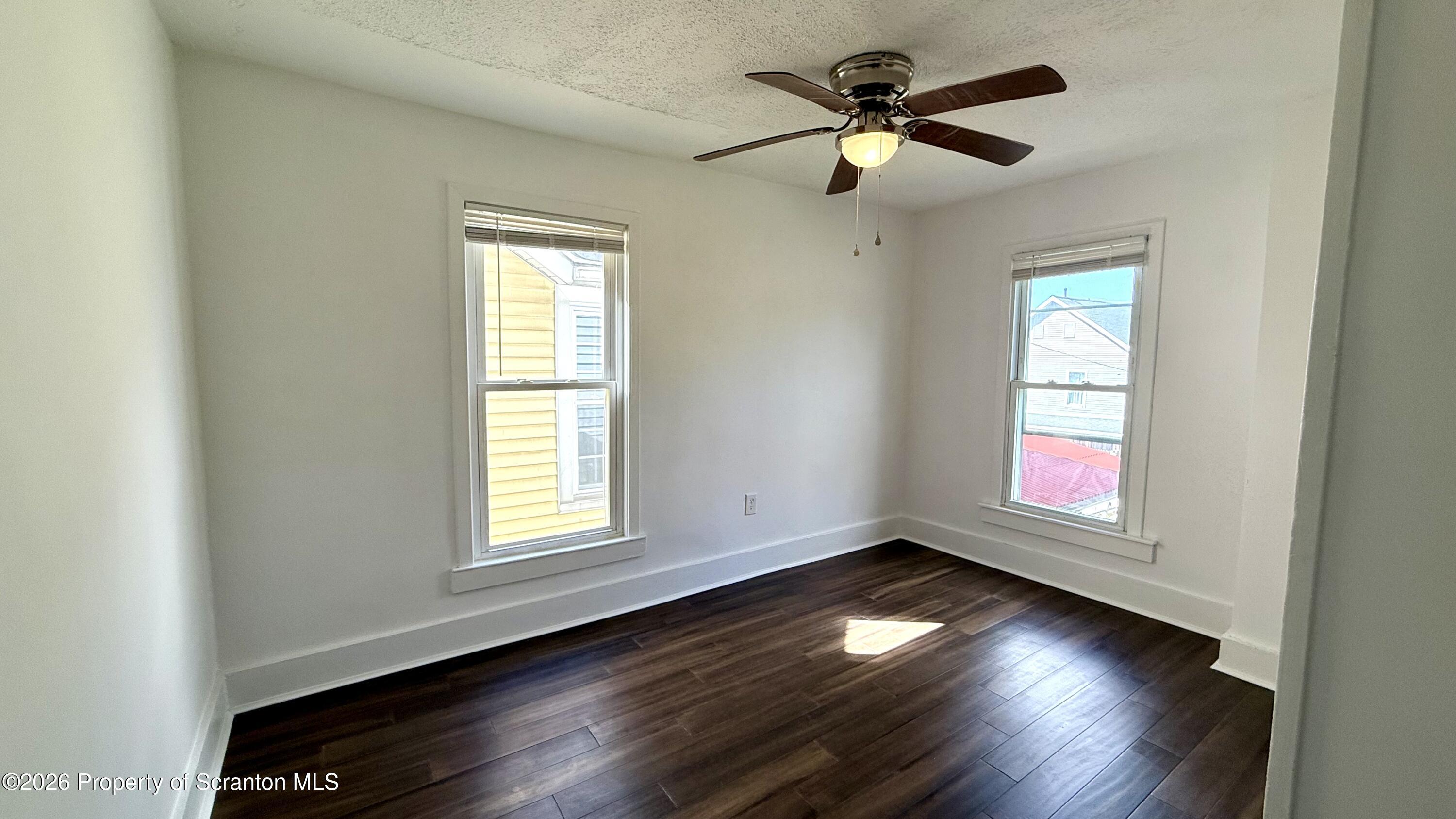 1032 Chestnut Street Sunbury, PA 17801 - Photo 12 of 25 an empty room with wooden floor and windows