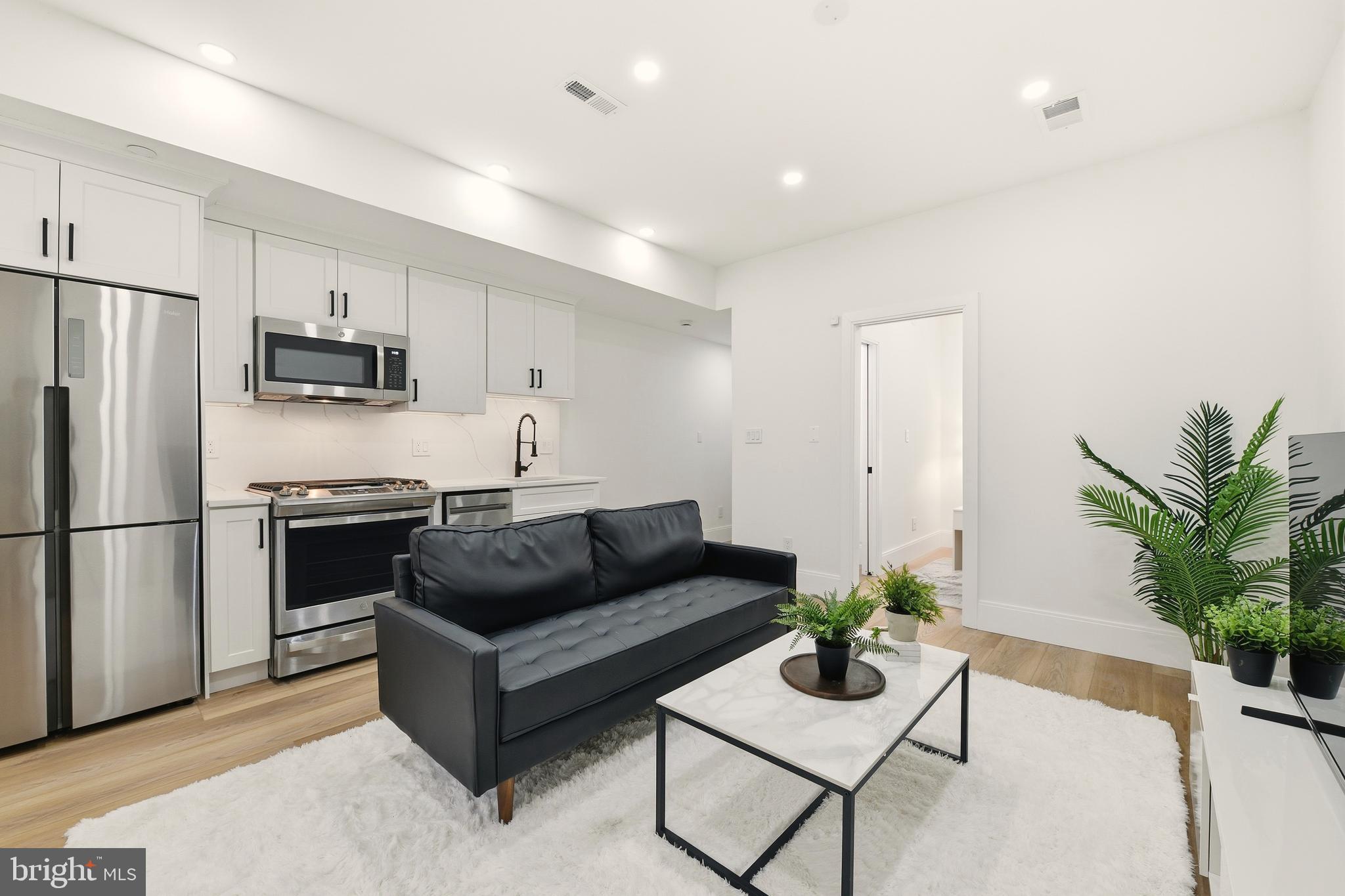 1714 Euclid Street Northwest, Unit 2 Washington, DC 20009 - Photo 4 of 20 a living room with furniture white wooden floor and a refrigerator