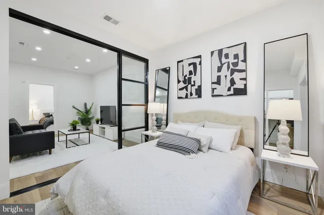 a bedroom with a large bed and paintings on the wall