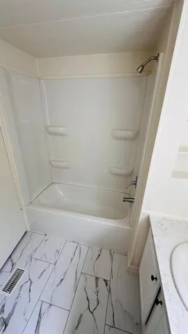 a bathroom with a bathtub and shower