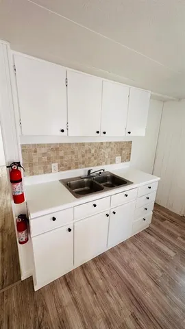 a kitchen with granite countertop white cabinets and white appliances
