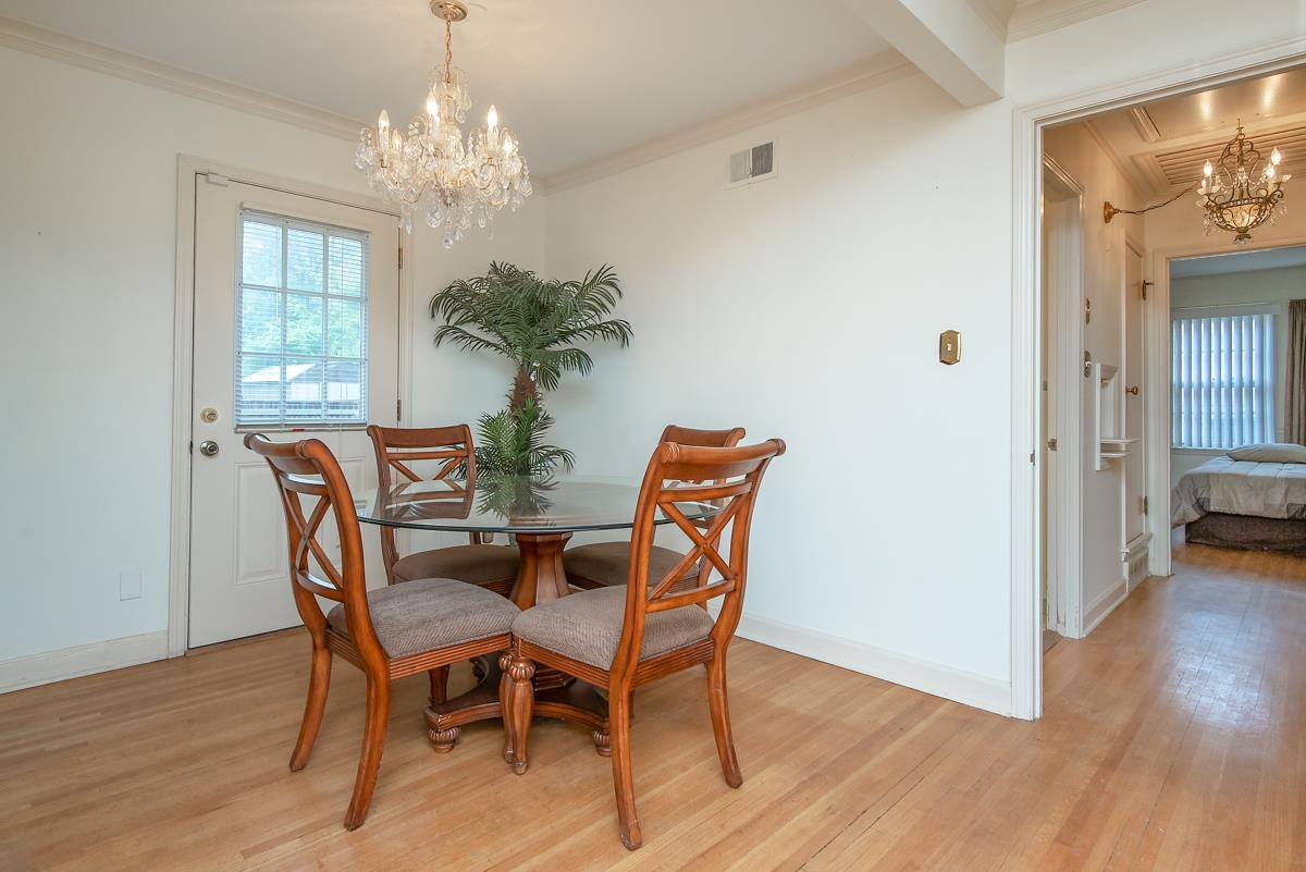4635 Boyce Road Memphis, TN 38117 - Photo 7 of 19 a dining room with furniture wooden floor a potted plant and a chandelier
